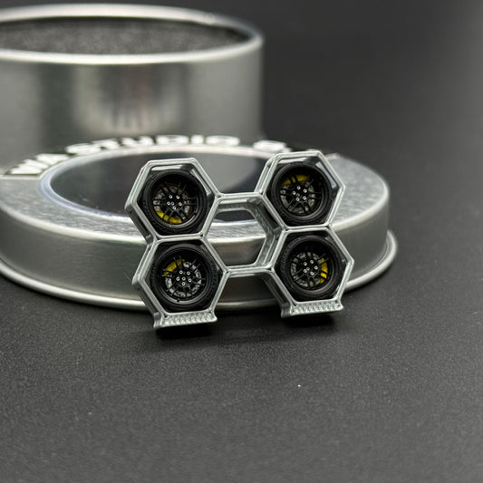 WA STUDIO 1/64 wheels, pair with hex-pattern black hubs and metallic rims, side view