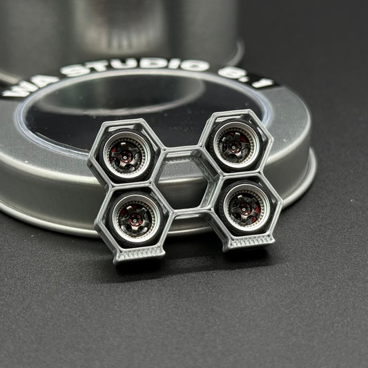 Toy wheel with four hex lug openings and four circular accents on a silver-gray rim