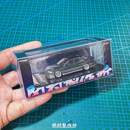 1/64 display box with clear cover showing dark car model on purple-pattern base