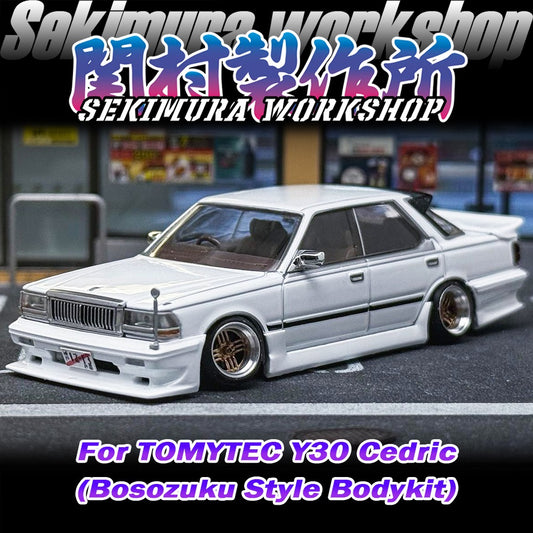 White sedan model with wide body kit, chrome grille, and lowered stance