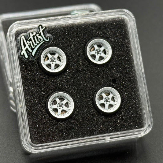 Four 1/64 S1 wheels in clear plastic case; silver multi-spoke rims on black insert