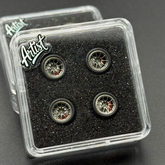 Four 1/64 model wheels with gold rims and red accents in clear case