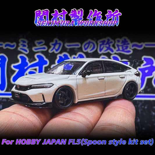 White sport car model on fingers, black wheels and front grille detail