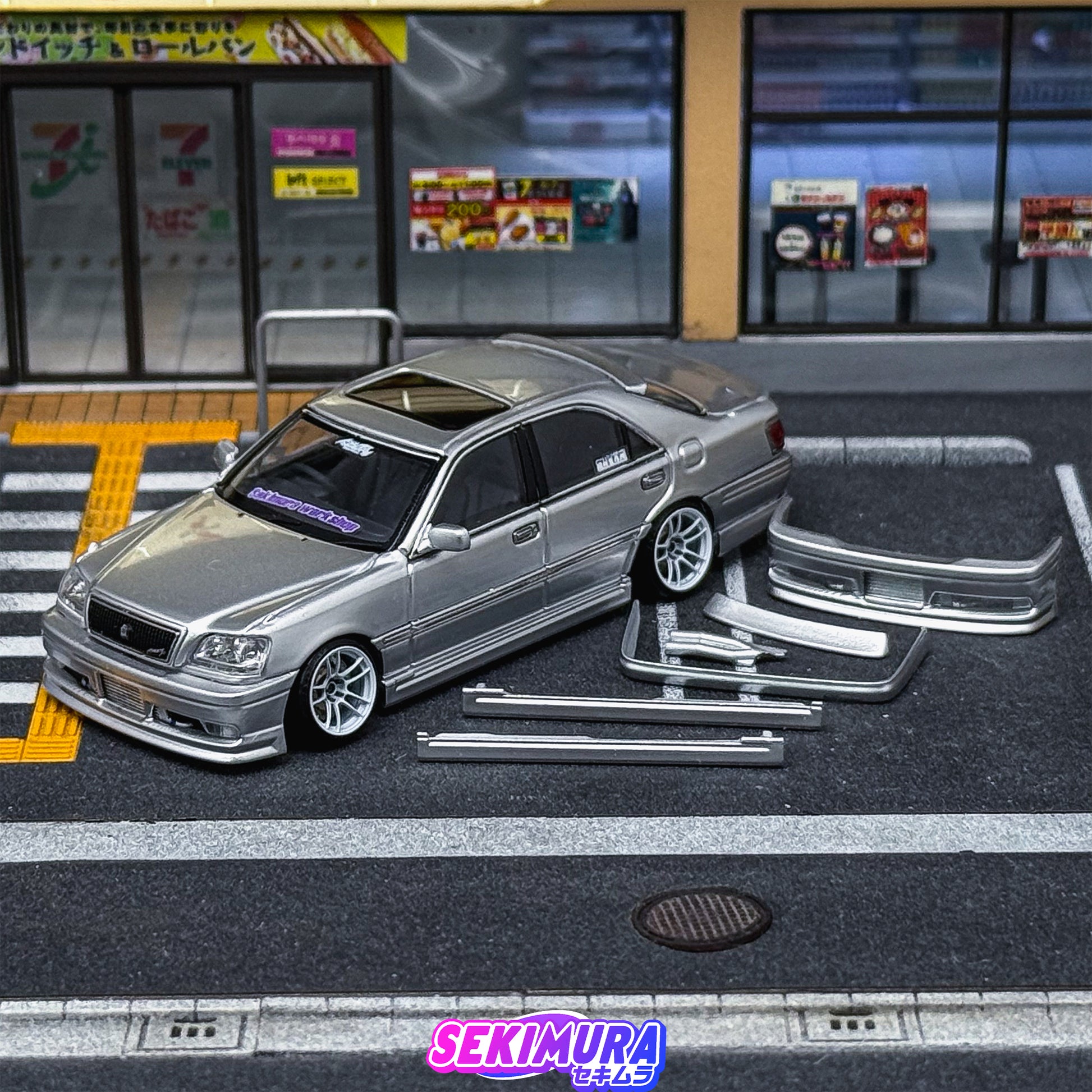Silver die-cast-style sedan with front bumper, side skirts, and rear lip
