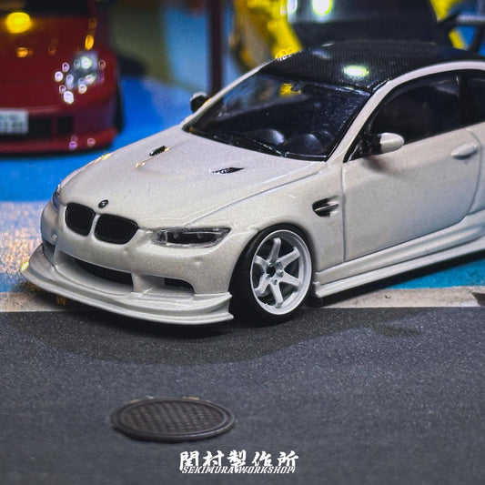 White assist-style bodykit on model coupe, front bumper lip and grille