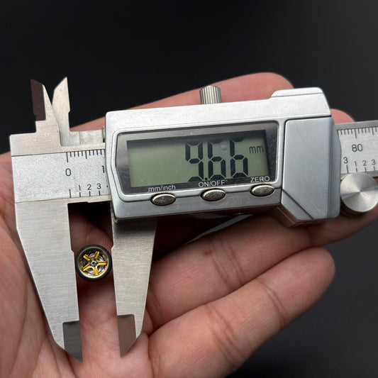 1/64 scale model wheel with metallic rim and four yellow hub details