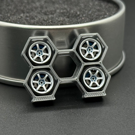 Die-cast wheel set with four silver rims and blue spoke centers on frame