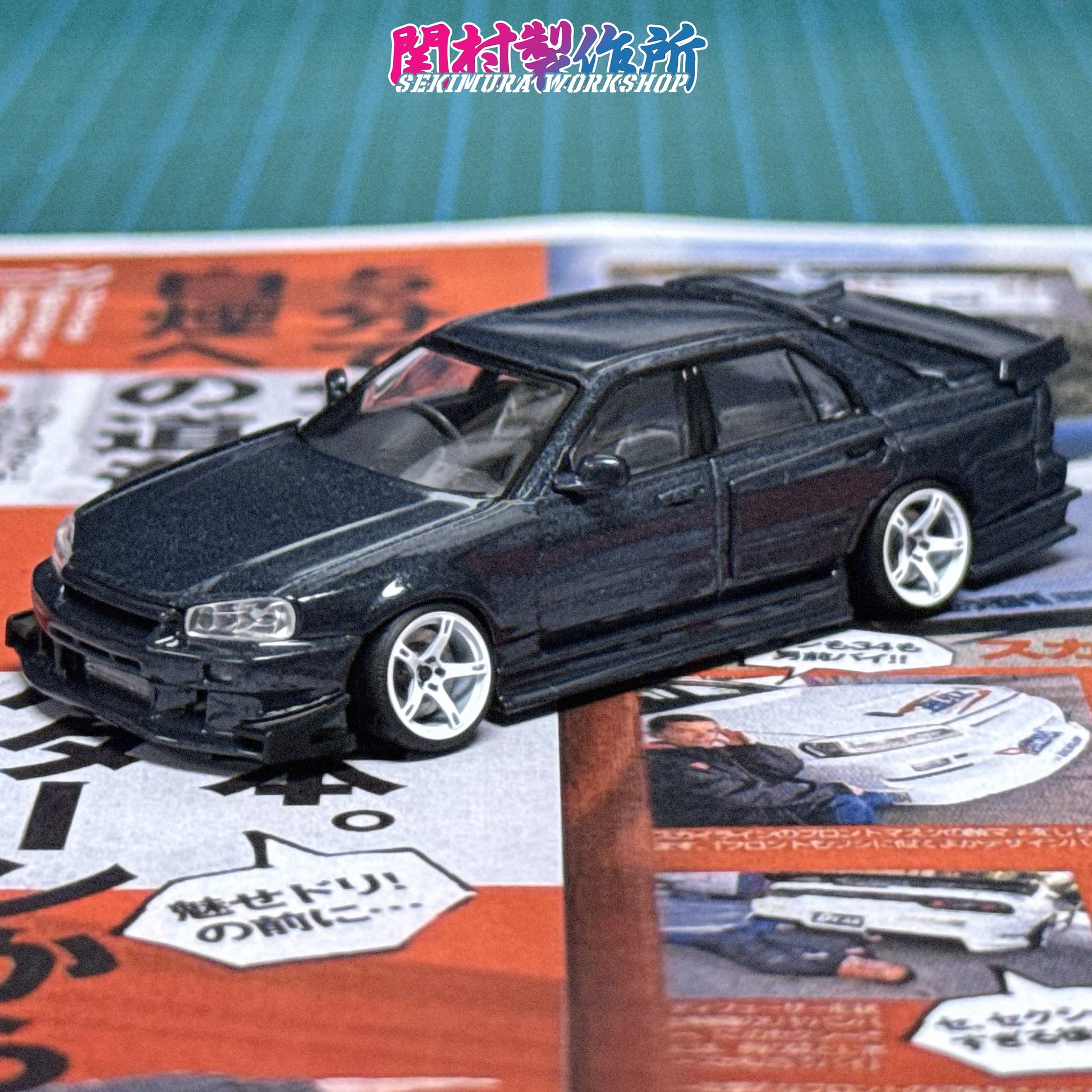 Dark gray-blue die-cast car model with hood vent and front lip spoiler