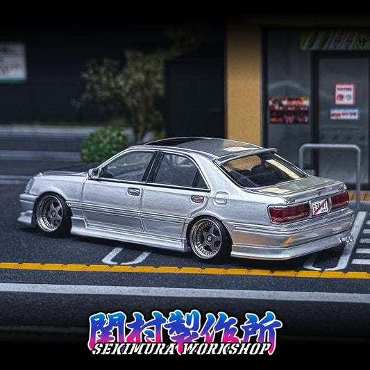Silver sedan showing rear three-quarter view with installed bodykit and side skirts