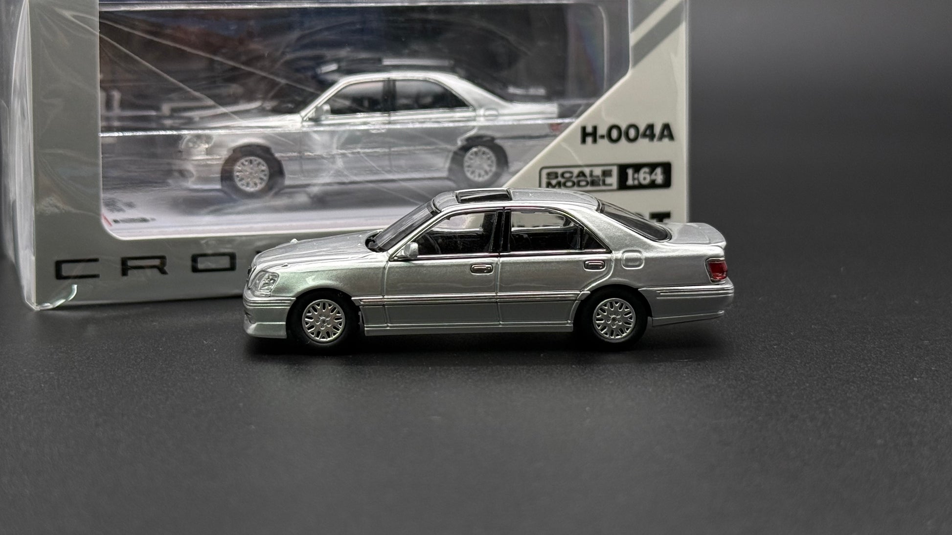 Dark silver die-cast sedan model, side 3/4 view with alloy-style wheels