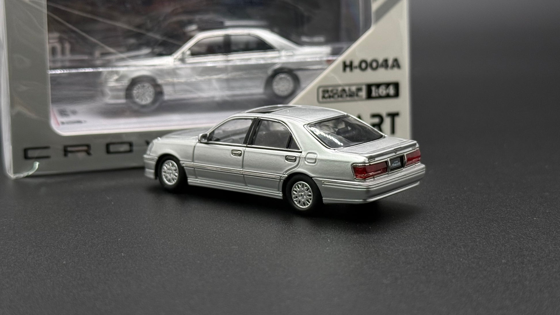 Silver die-cast sedan model, rear 3/4 view with detailed taillights and wheels
