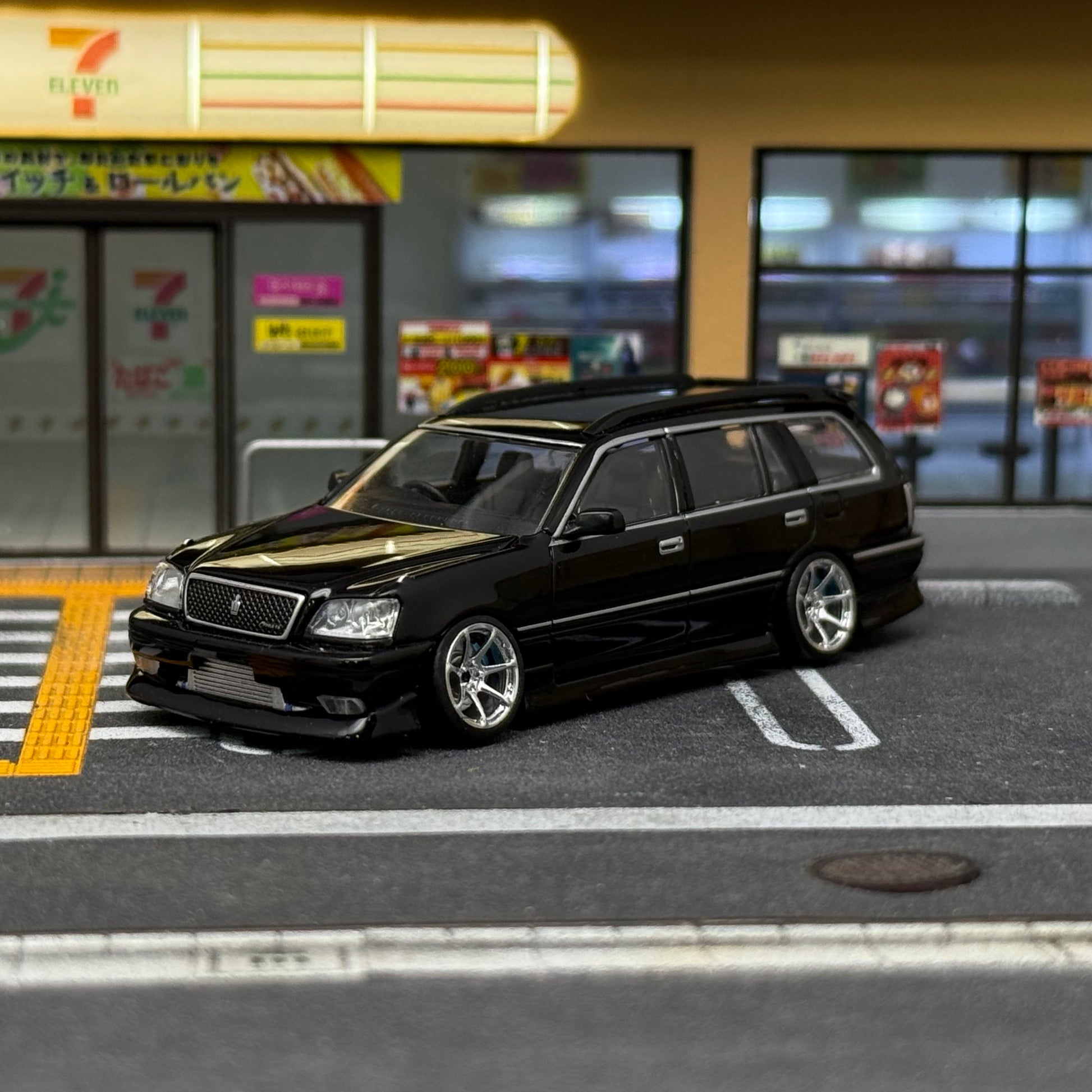 Die-cast black car with chrome wheels, 1/64 scale