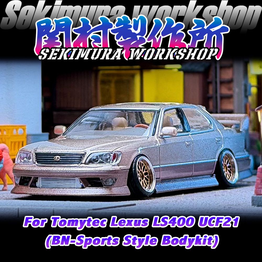 White model sedan with front sport bumper, grille, and lowered stance