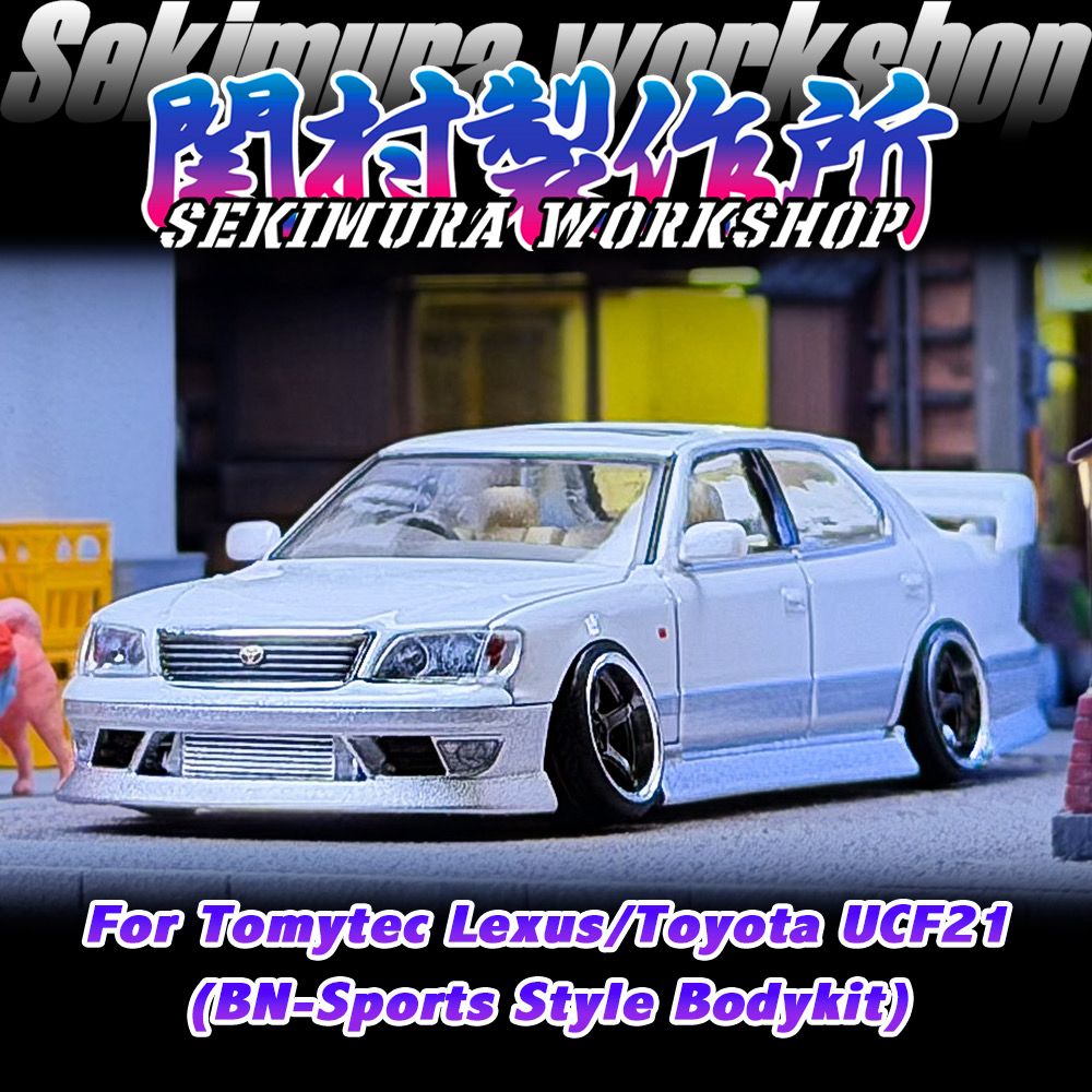Two-tone white model sedan with front bumper, grille detail, and lowered stance