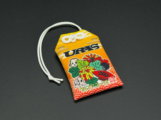 Traffic safety omamori charm pouch, orange and yellow with floral artwork and white cord