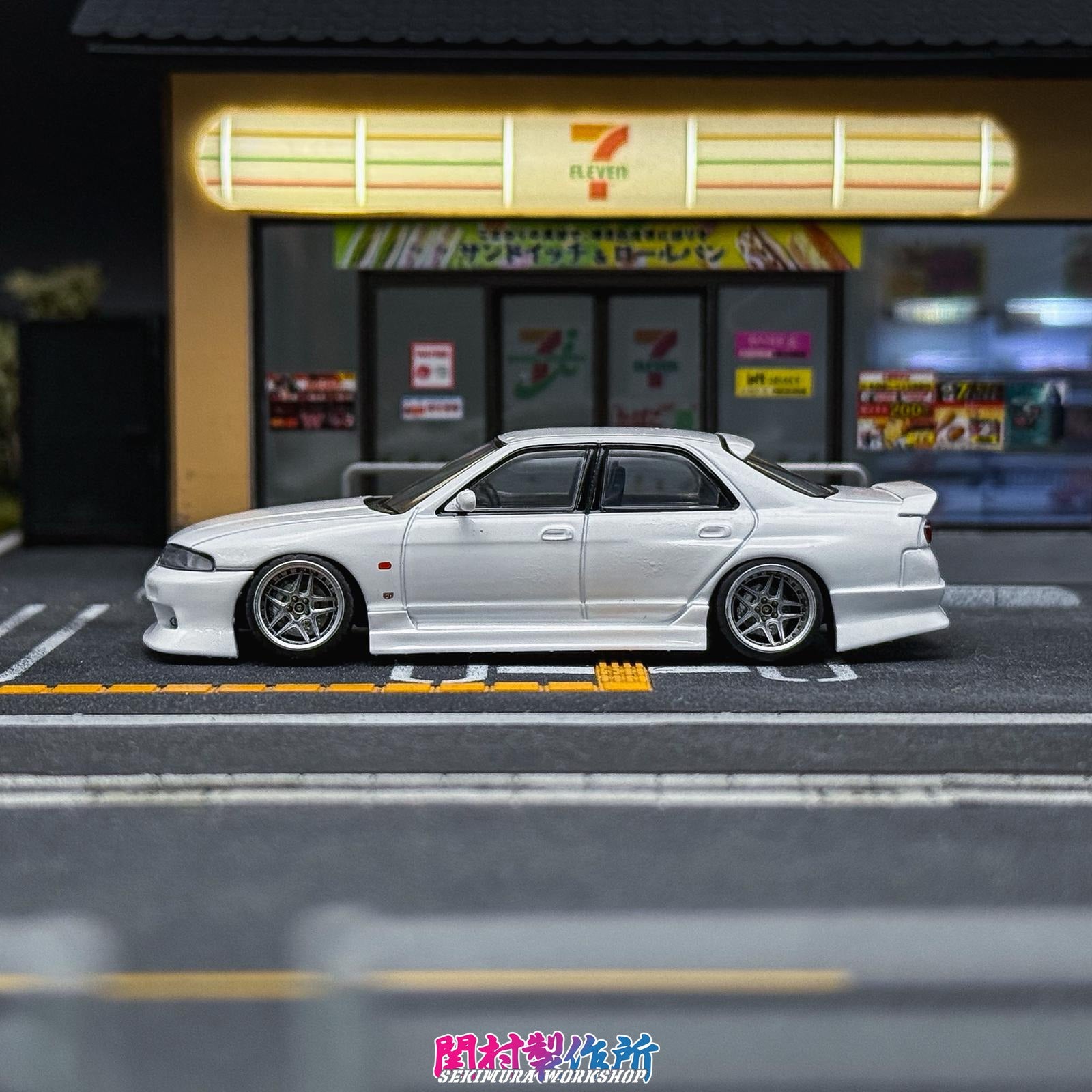 White modified car model with bodykit, front and rear aero pieces visible