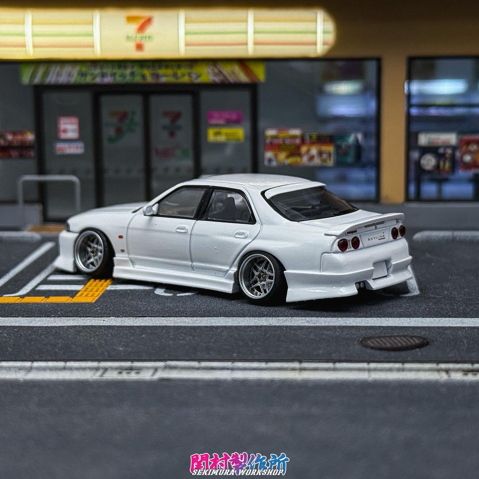 White modified car model with rear spoiler and side skirts, three-quarter view