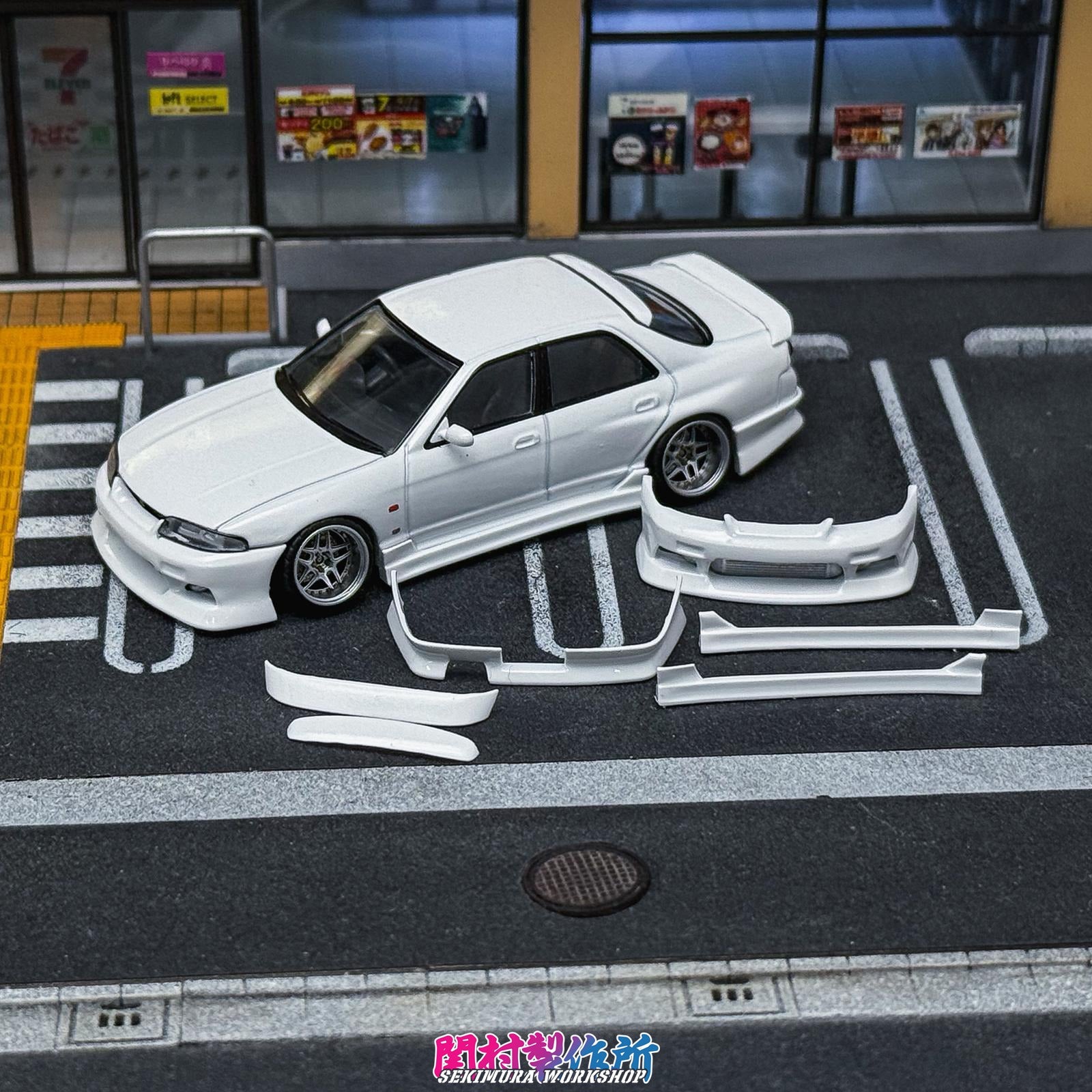 White modified Nissan-style car with front lip and side skirts on display