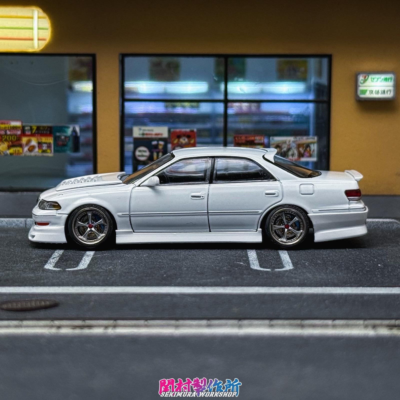 White JZX100 Mark2 model sedan with body-colored trim and front lip, side profile