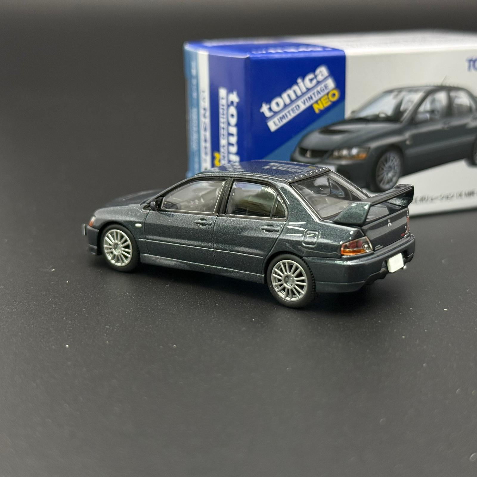 Dark gray die-cast car model with rear-right 3/4 view and raised hood