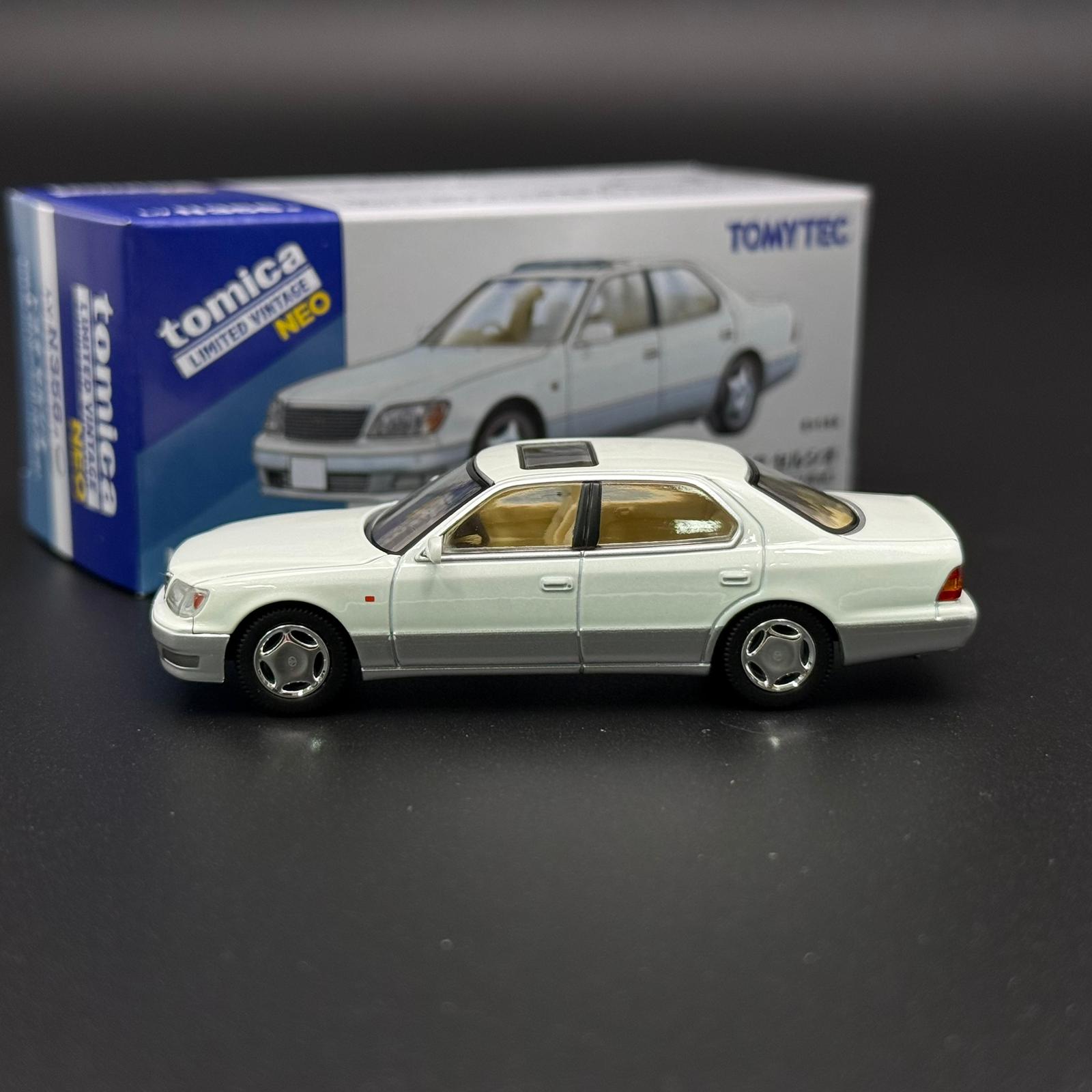 White two-door die-cast car model in side profile with silver wheels