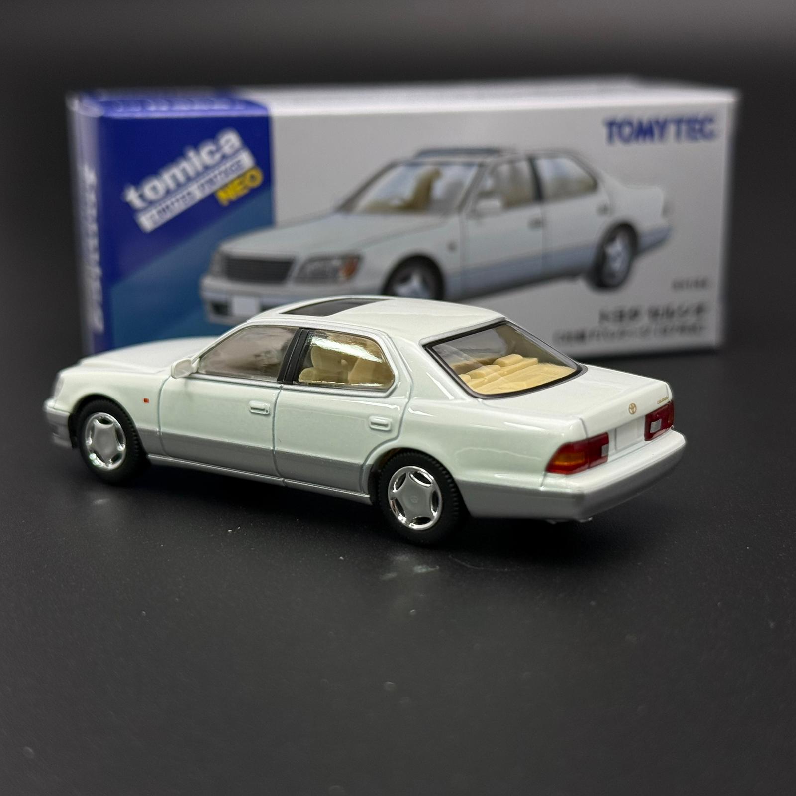 White two-door die-cast car model in rear three-quarter view with gold-tinted headlights
