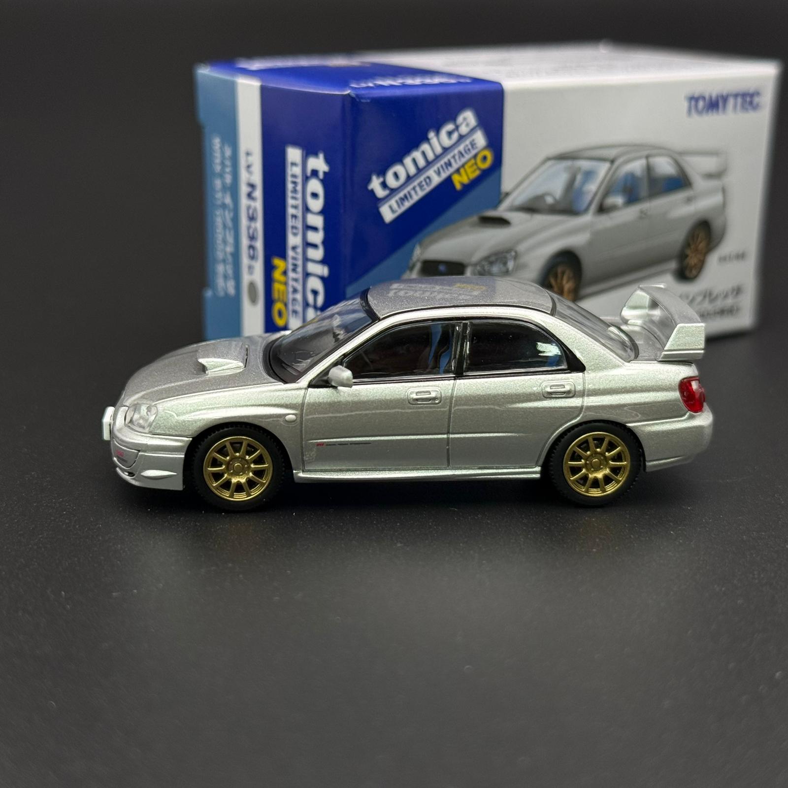 Silver Subaru WRX STI 2003 die-cast model car, side profile with gold wheels