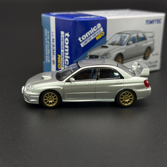 Silver Subaru WRX STI 2003 die-cast model car, side profile with gold wheels