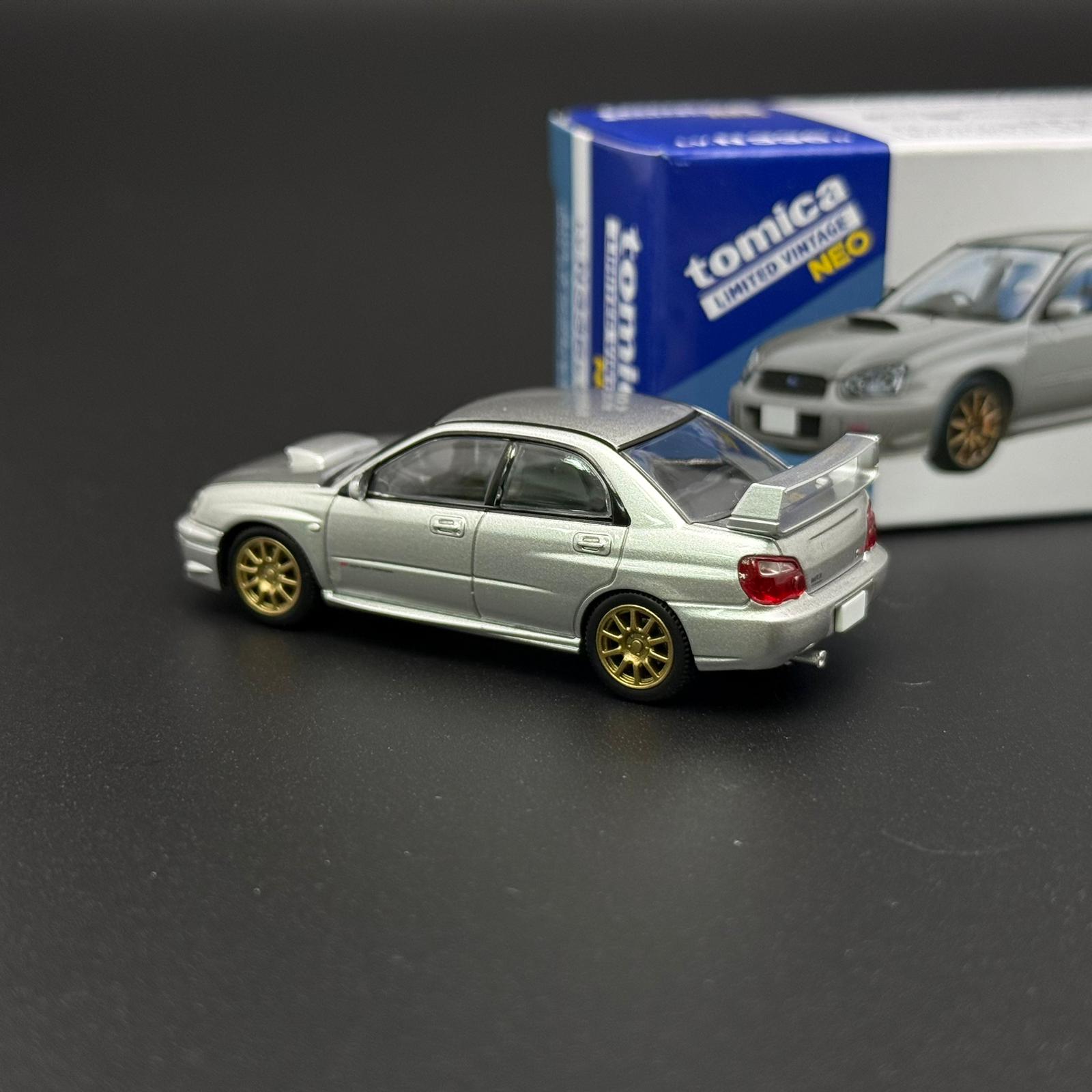 Silver Subaru WRX STI 2003 die-cast model car, rear three-quarter view with gold wheels