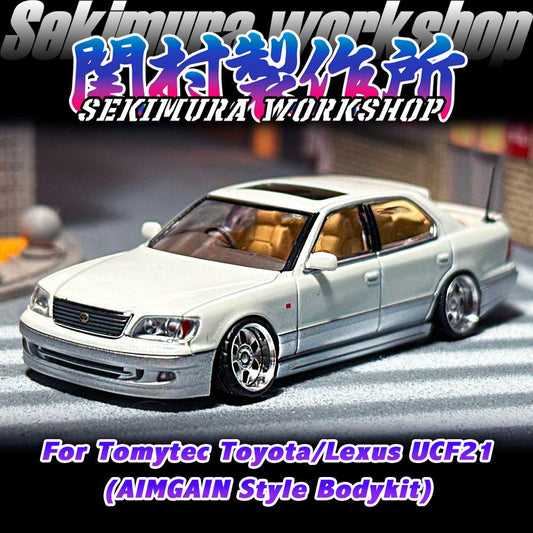 Two-tone white die-cast sedan model with aftermarket body kit, front three-quarter view