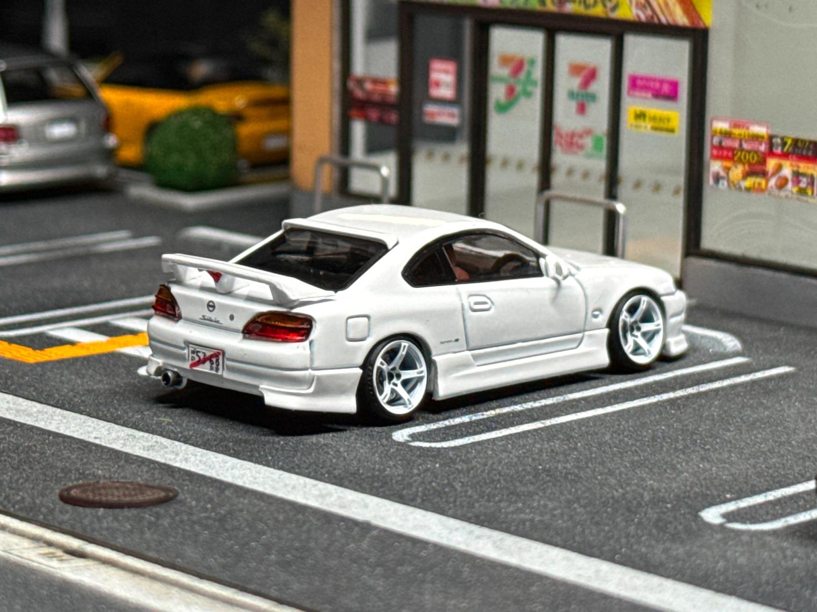 White sports car bodykit model from rear three-quarter, with spoiler and tail lights