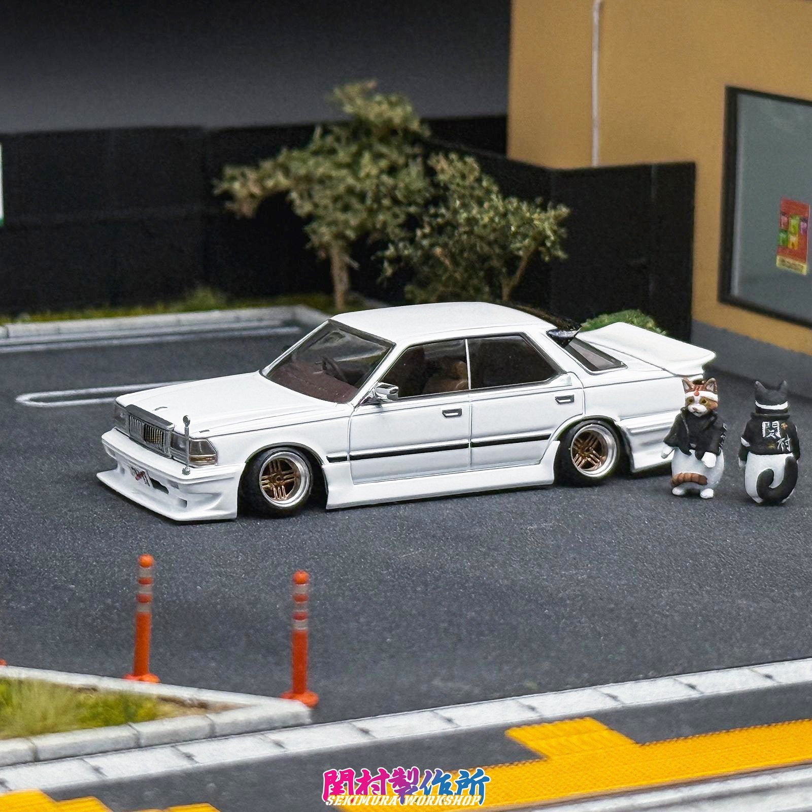 White sedan model with rear wing and front splitter, lowered stance
