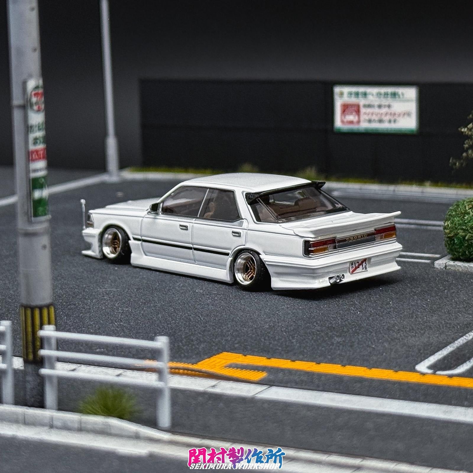 White sedan model with wide body kit, chrome grille, and low-profile wheels