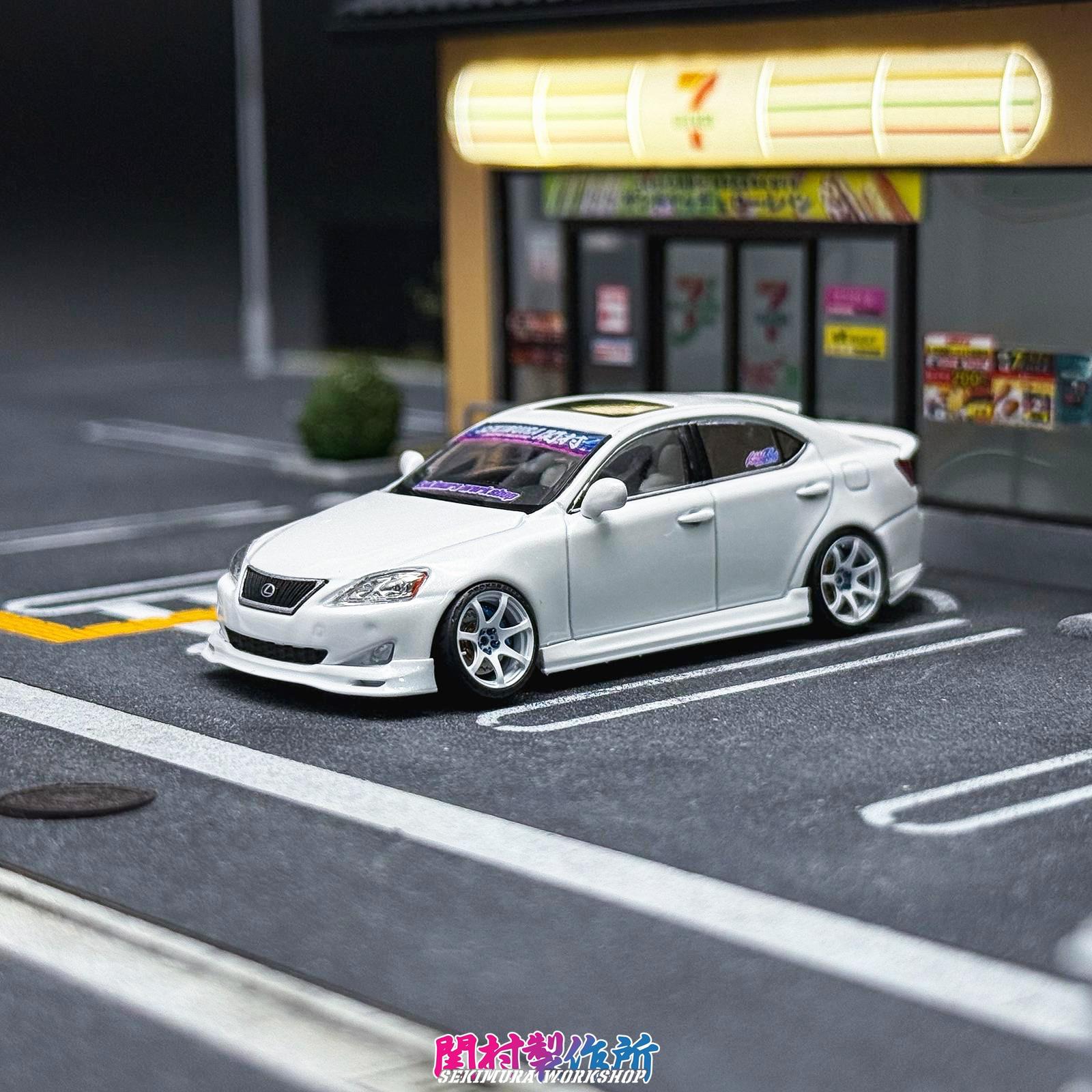 White Lexus IS350-style bodykit car with front lip and aftermarket wheels, front 3/4 view
