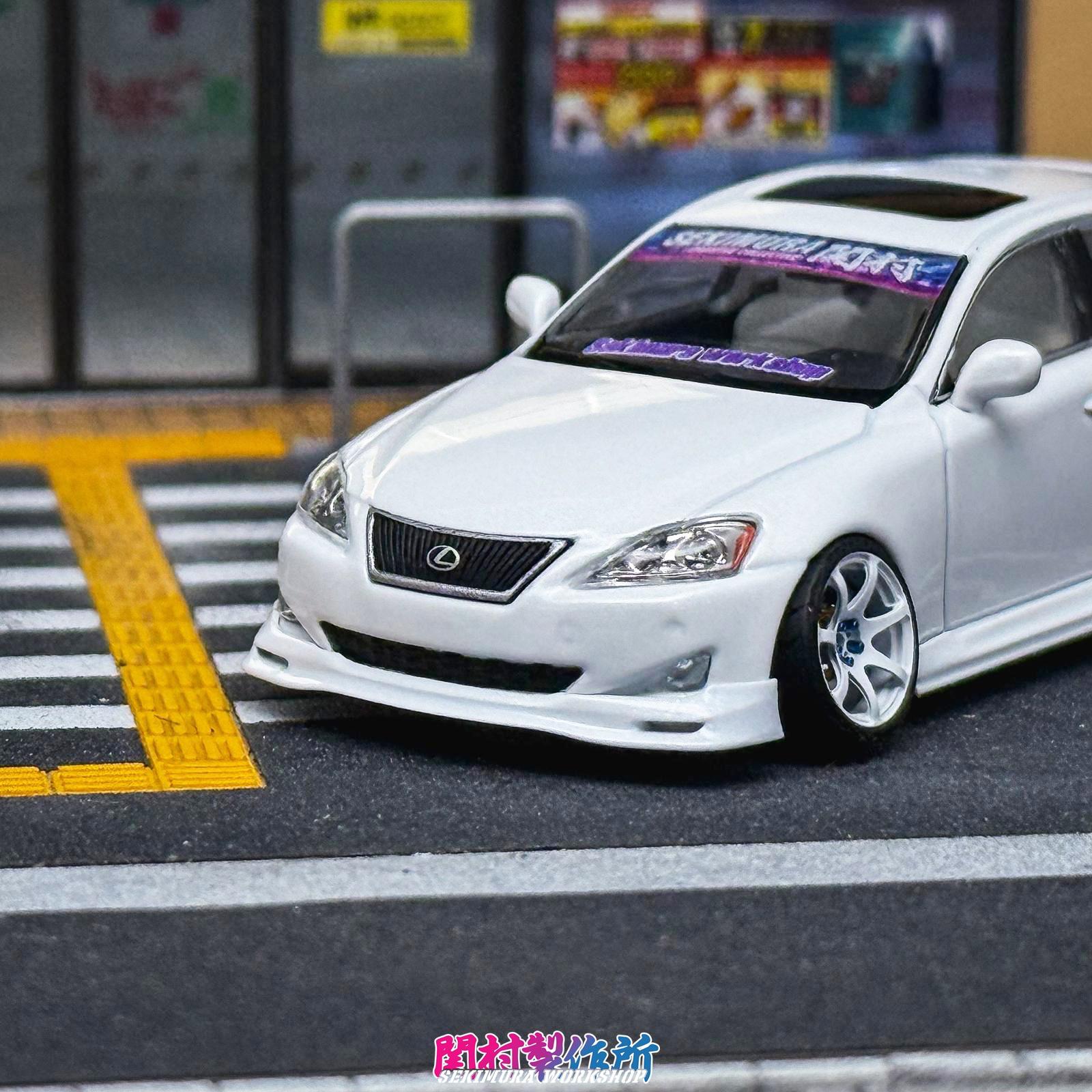 White Lexus IS350-style bodykit car front with grille, splitter lip, and low-profile wheels