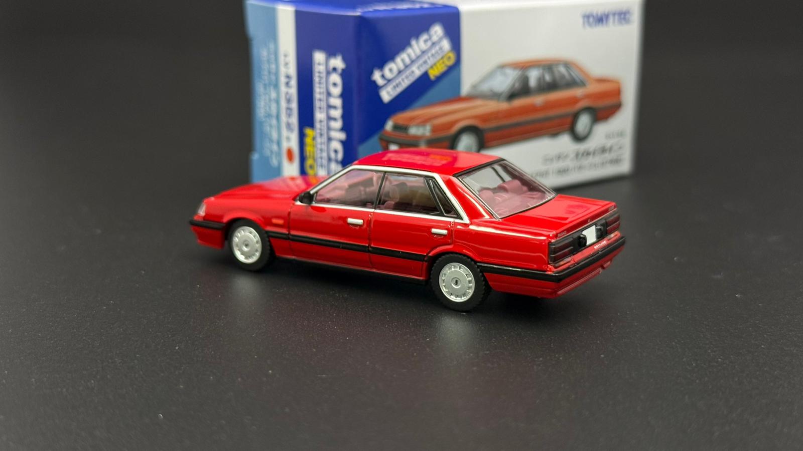 Red 1/64 scale 4-door sedan model car, side 3/4 view