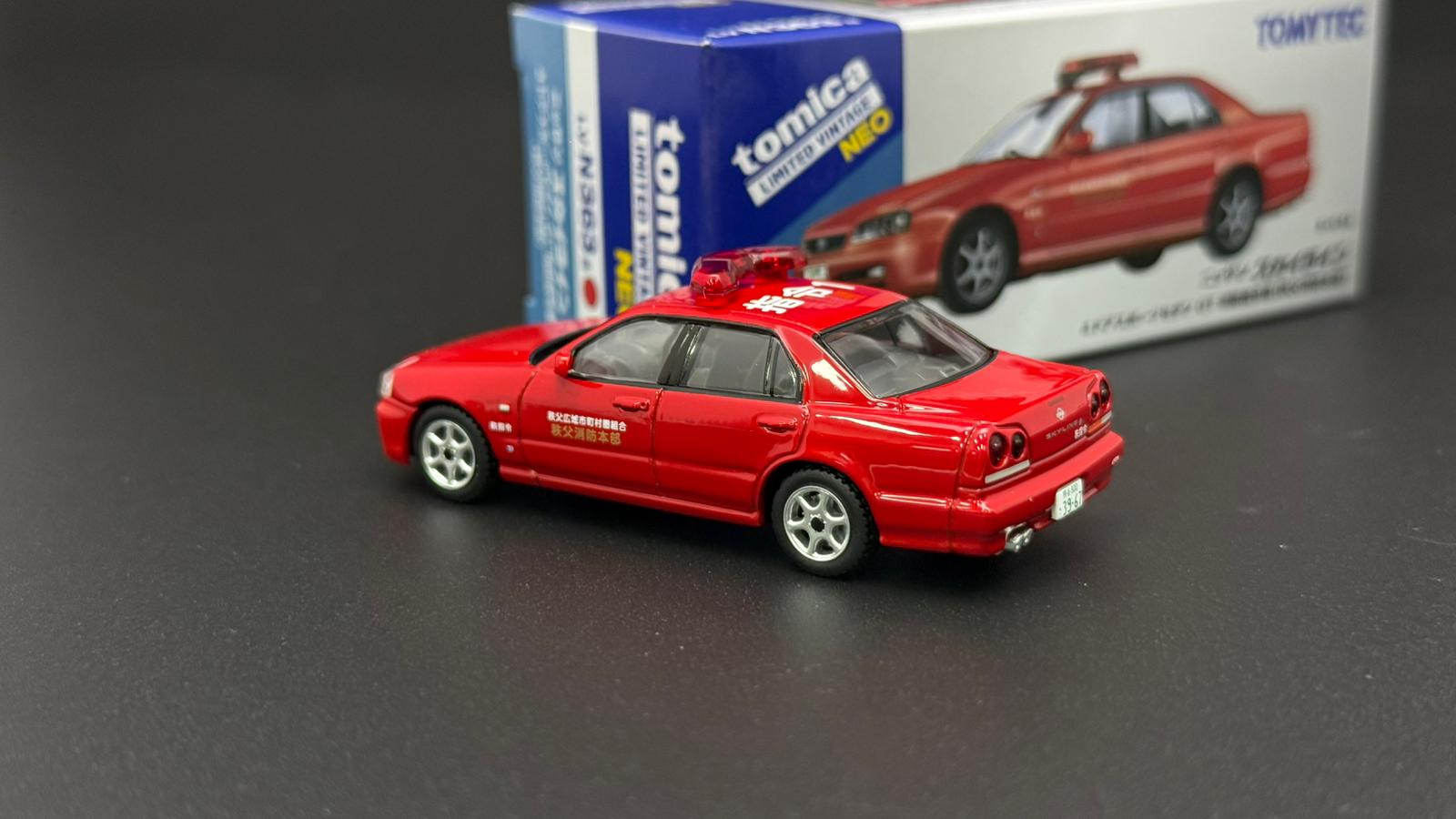 Tomytec 1/64 ER34 4-Door red model car, front three-quarter view