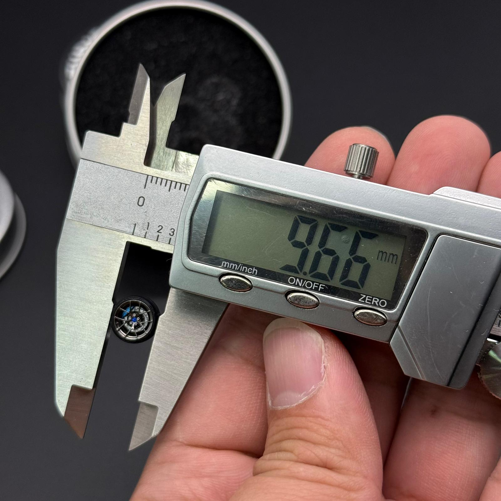 Chrome wheel rim measured with digital caliper; measurement readout visible