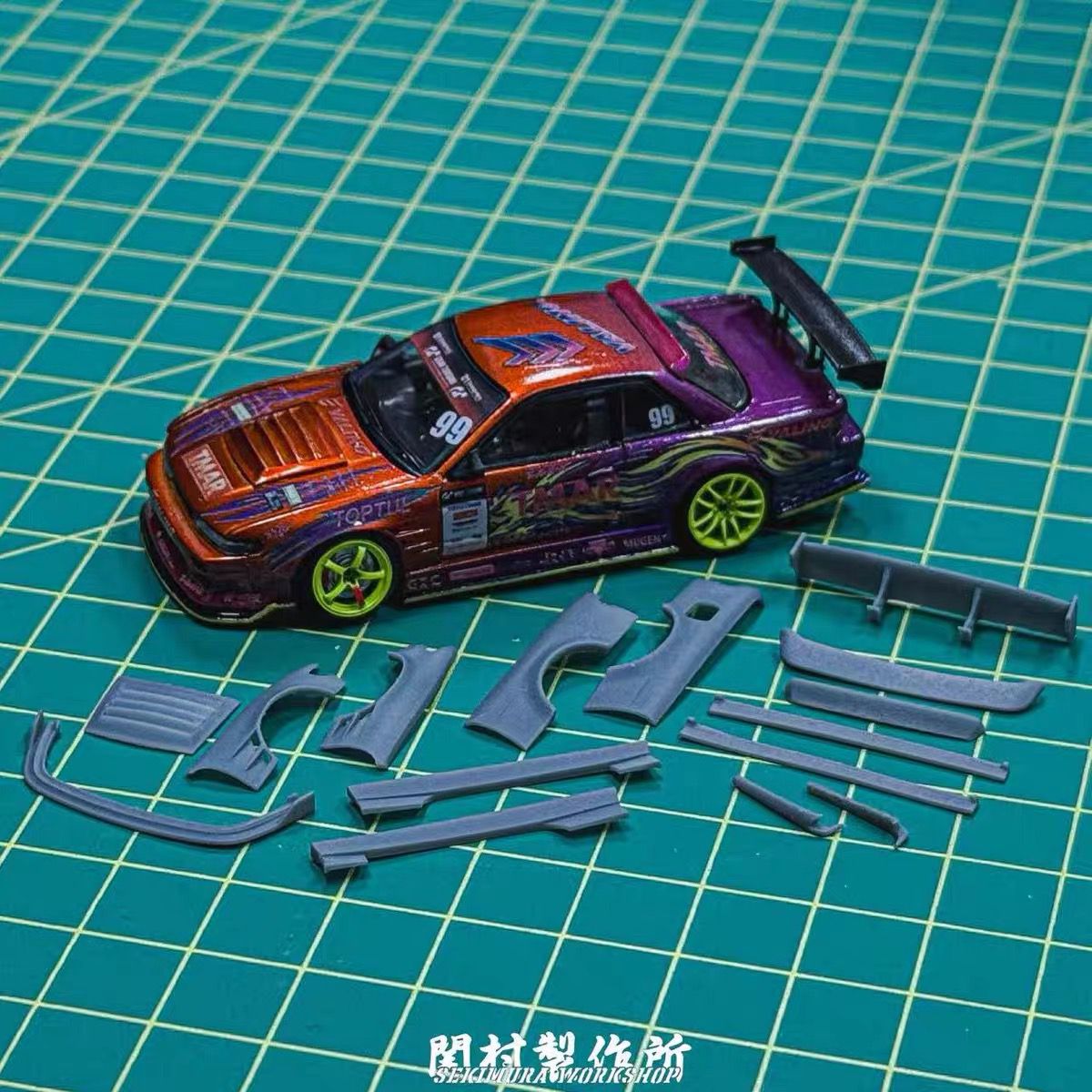 Nissan S13 body kit parts with fitted model car on green cutting mat