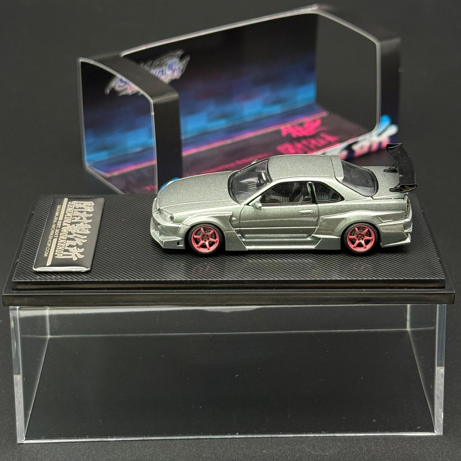 Light green scale model car with black roof, red wheels, and rear spoiler on base