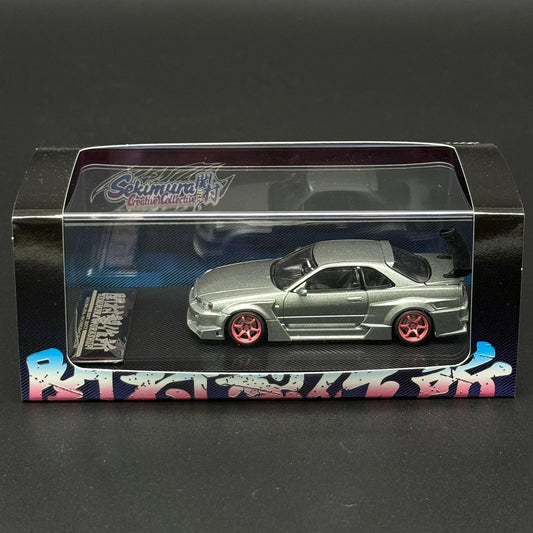 Light green scale model 2-door car with black hood and red wheels in clear case