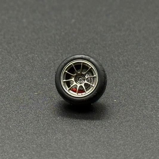 Single 1/64 model wheel with black tire, gold rim, and red spokes