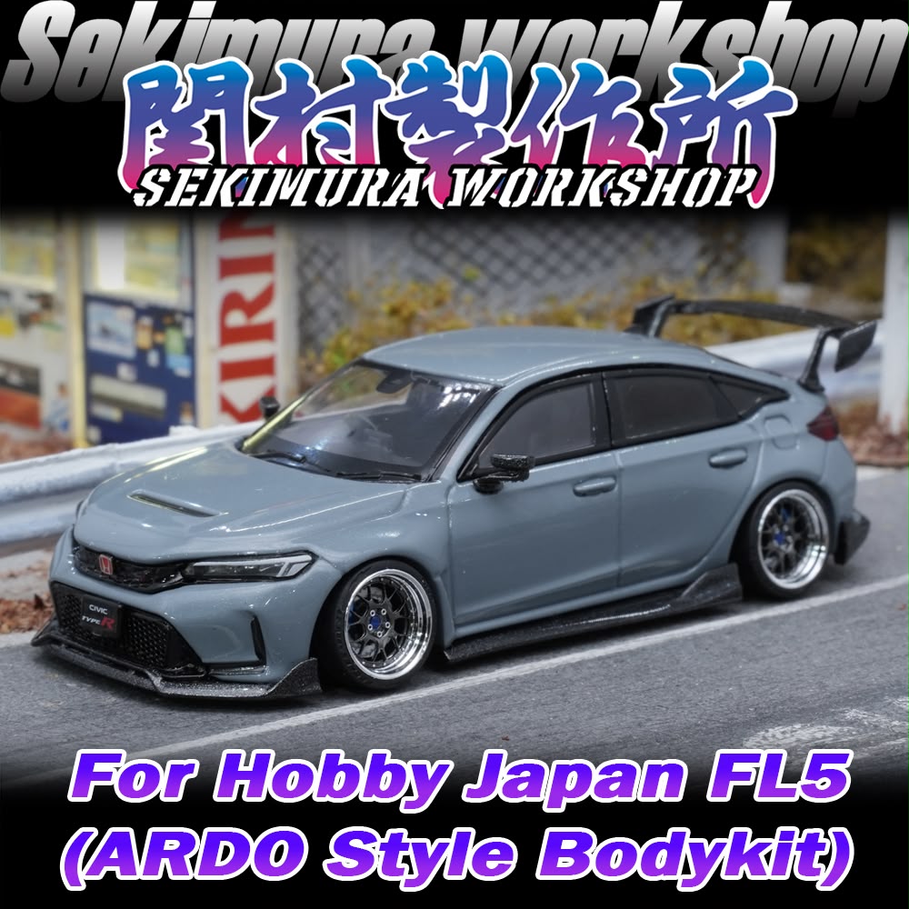 Light blue model car front three-quarter view with body kit and rear wing