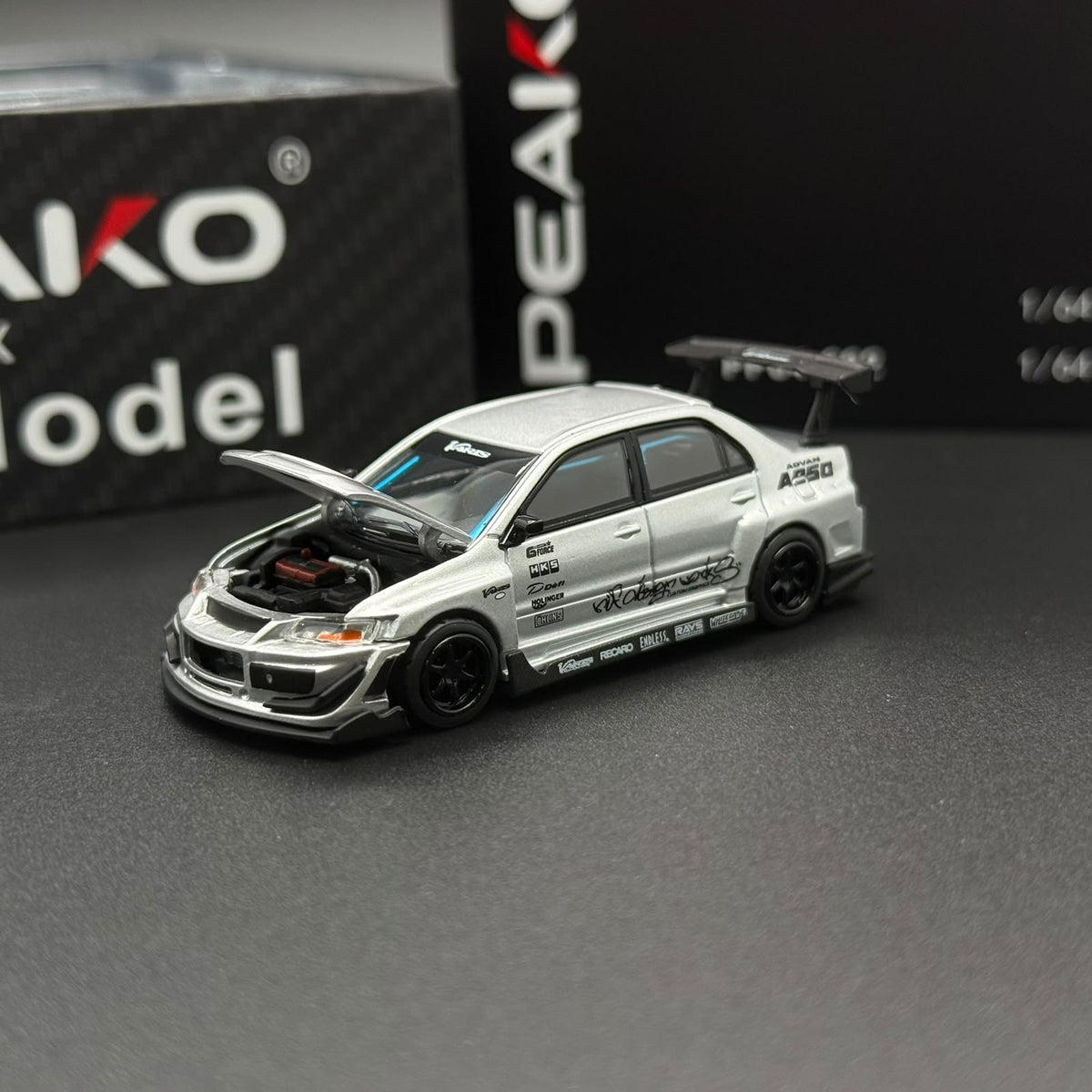 PEAKO 1/64 silver die-cast model car with side decals and black wheels