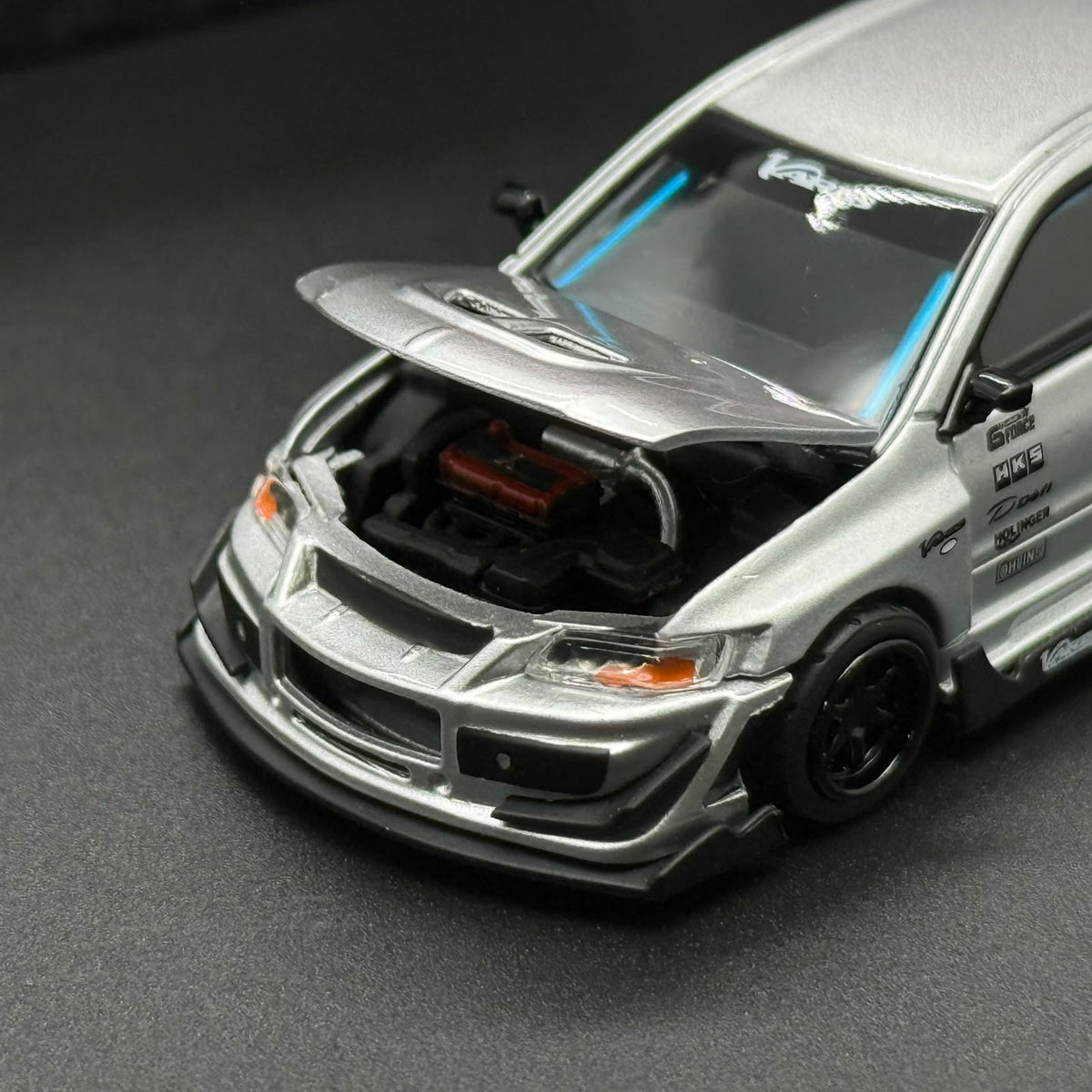 PEAKO 1/64 silver die-cast model car with open hood and black engine bay