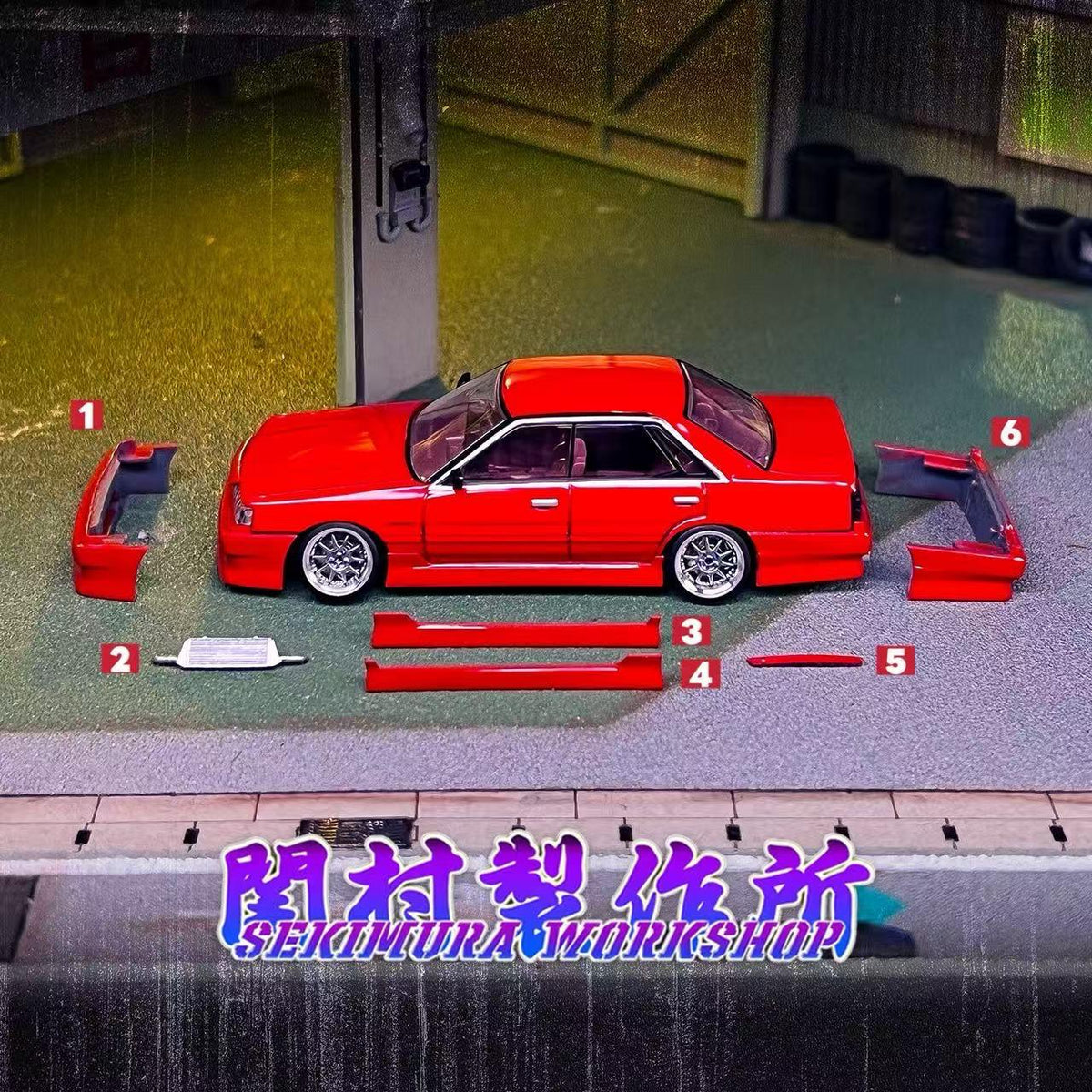 Red scale model sedan with bodykit parts laid out on base