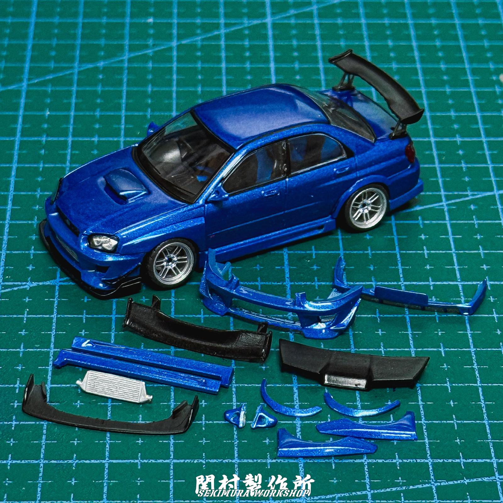 Blue SUBARU WRX STI bodykit parts and model car on cutting mat