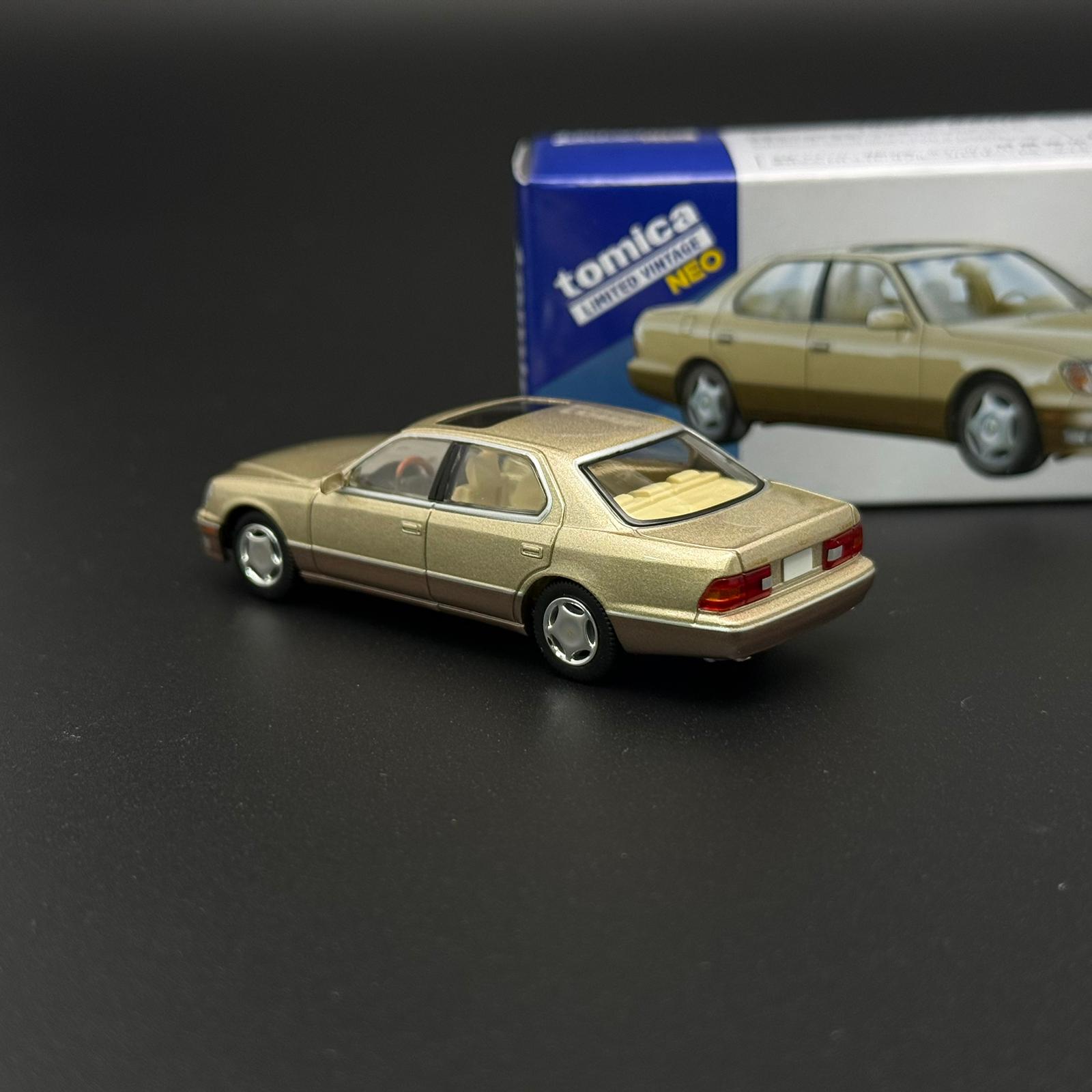 Gold two-door die-cast car model in rear three-quarter view with silver wheels