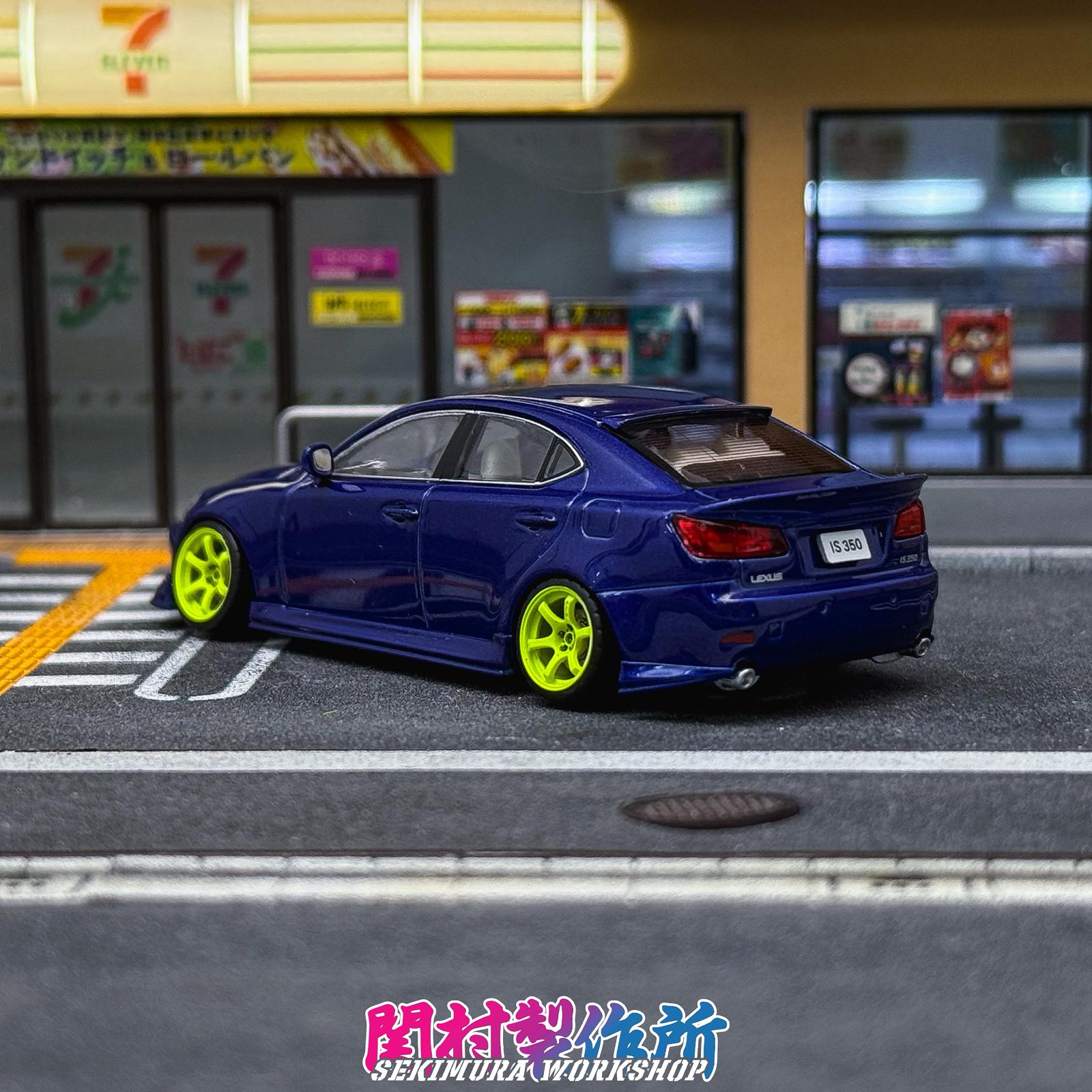 Blue Lexus IS350-style bodykit car with side skirts and rear wing, rear 3/4 view