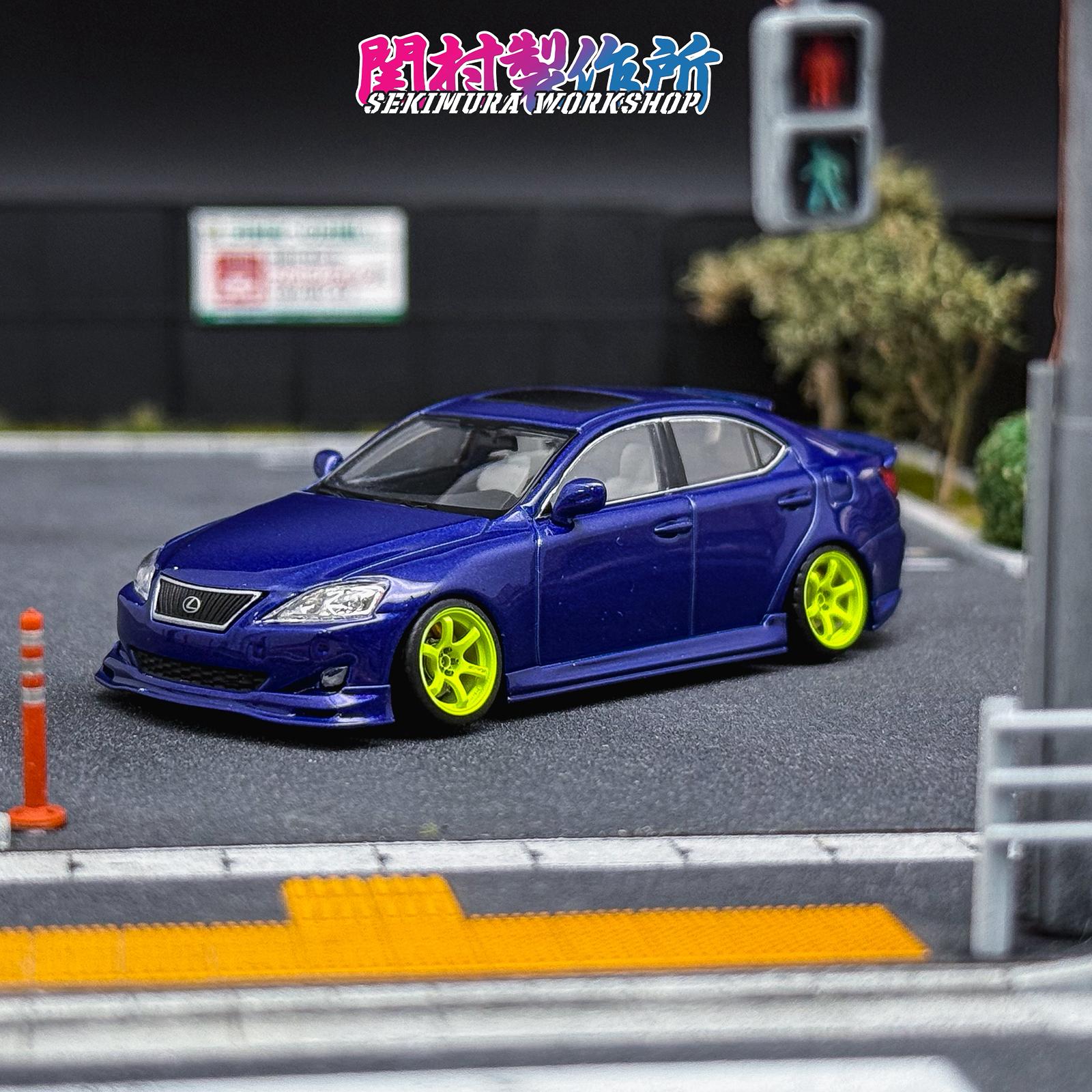 Blue Lexus IS350-style bodykit car with front splitter lip and neon wheels, front 3/4 view